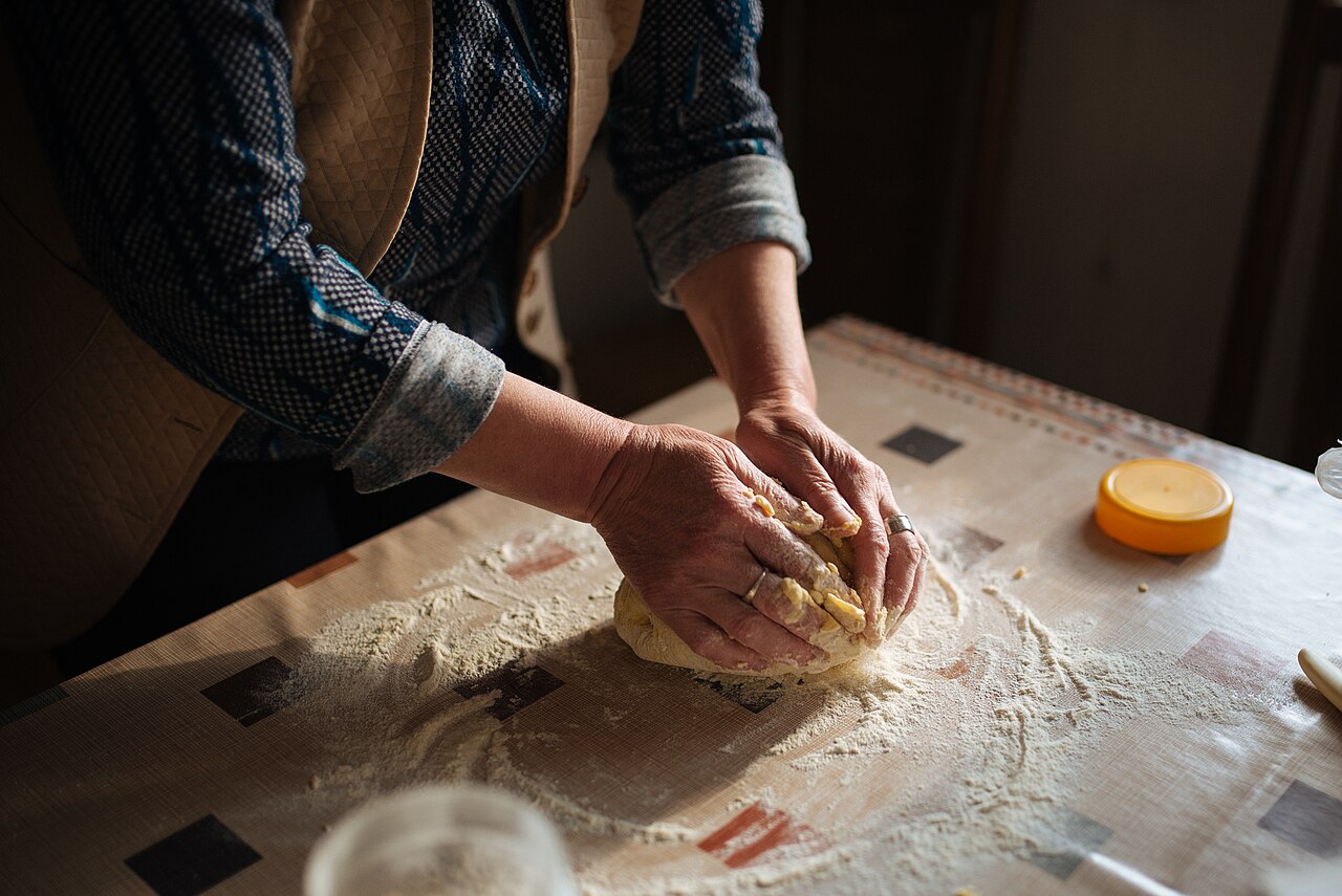 Baker kneading bread dough by hand
